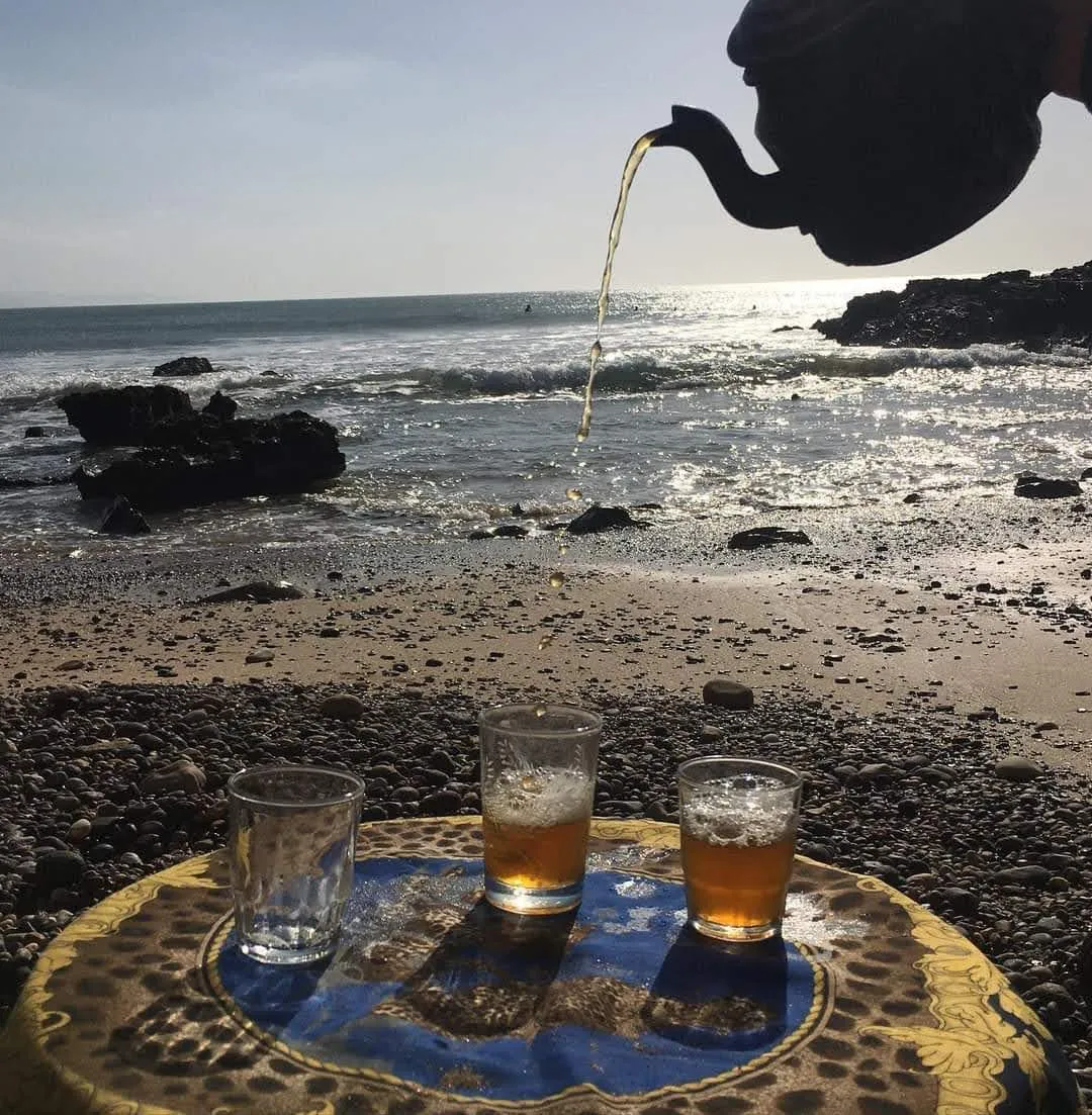 Le thé versé dans les verres sur un plateau posé sur la grève