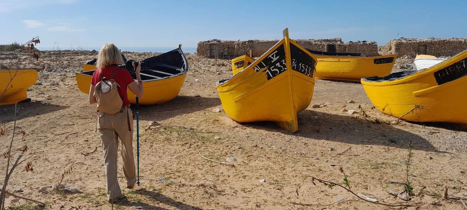 Une marcheuse photographie les barques jaunes de Taganza