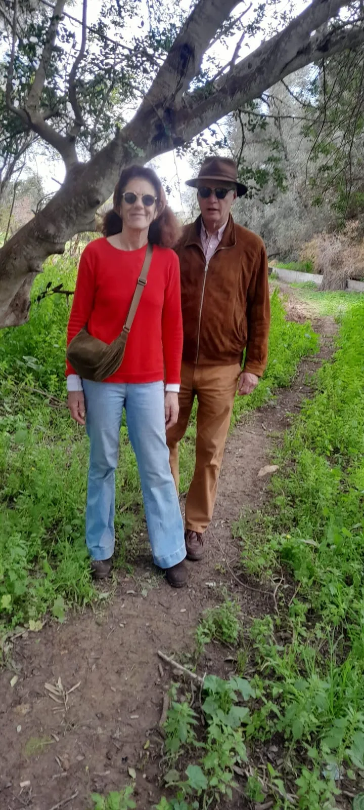 Deux marcheurs sur le sentier de terre, sous les oliviers