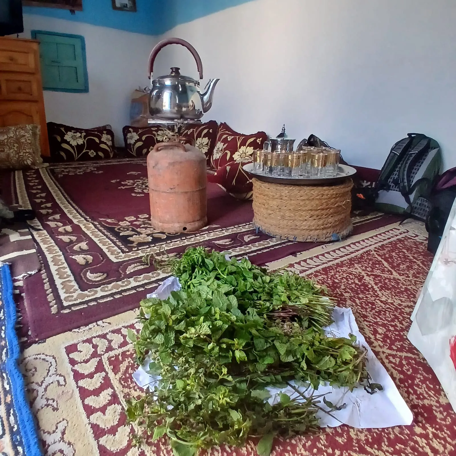 Intérieur berbère : théière et botte de menthe fraîche sur le tapis