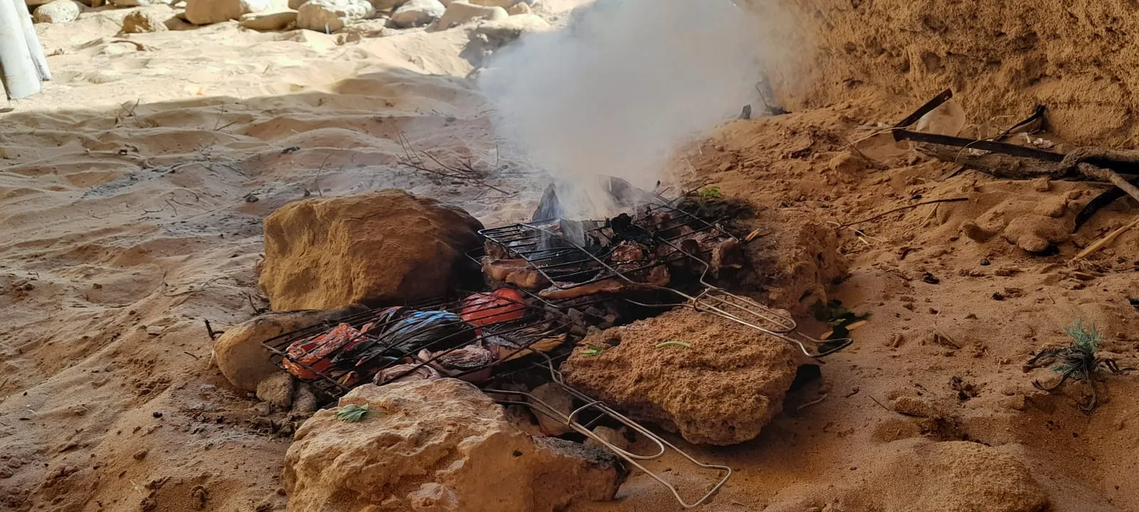 Le feu de bois monté à même le sable pour le déjeuner