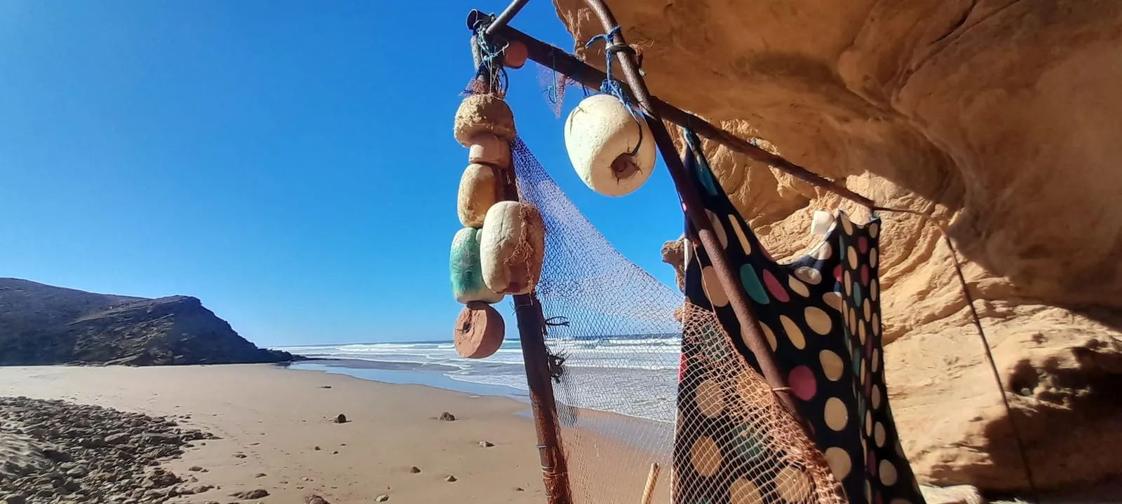 Flotteurs et filet suspendus à une perche sur la plage