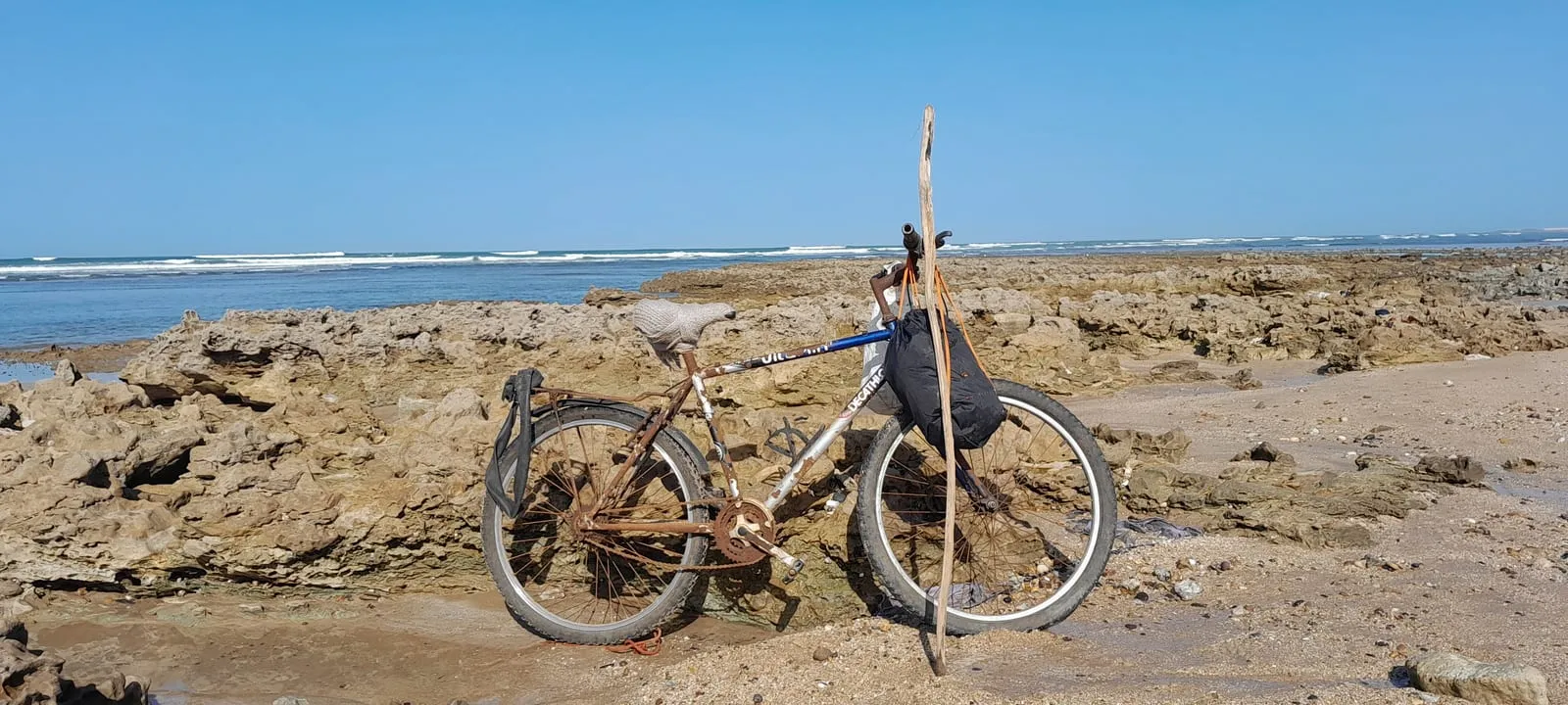 Vélo et canne posés contre la roche face à l’océan